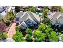 Beautiful aerial view of a home featuring a pool and lush landscaping on a sunny day at 1266 Imperia Dr, Henderson, NV 89052