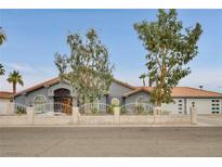 Charming single-story home showcasing a decorative iron gate, tile roof, and manicured landscaping at 1970 Del Font Ct, Las Vegas, NV 89117