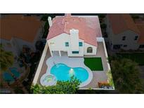 Aerial view of a backyard with a pool, spa, and small grass area of a home with a terracotta tile roof at 2107 Fountain Springs Dr, Henderson, NV 89074