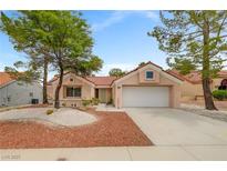 Inviting single-story home with a two-car garage and meticulously landscaped front yard, complete with mature shade trees at 2430 Sungold Dr, Las Vegas, NV 89134