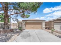 Charming single-story home with a two-car garage and well-maintained landscaping with a large tree in the front yard at 2432 Shady Hill Ave, Las Vegas, NV 89106