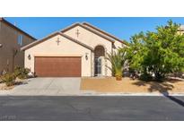 Inviting single-story home featuring a two-car garage, desert landscaping and an arched entry at 4916 White Jade St, North Las Vegas, NV 89081