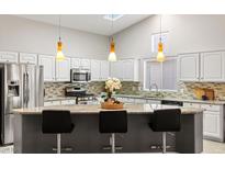 Bright kitchen features granite countertops, stainless steel appliances, and stylish pendant lighting at 5108 Molveno Ct, Las Vegas, NV 89130