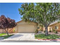 Charming single-story home featuring a well-manicured front yard with mature shade trees and a two-car garage at 5687 Harbour Pointe Ave, Las Vegas, NV 89122