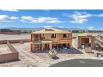 Two-story home under construction featuring a wooden frame and mountain views, with a dumpster nearby at 7121 Painted Skyline St, Las Vegas, NV 89118