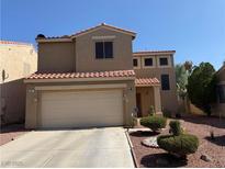 Charming two-story home featuring a two-car garage and desert landscaping under a clear blue sky at 977 Country Skies Ave, Las Vegas, NV 89123