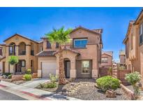 Charming two-story home features a desert landscape, a private two-car garage, and mature palm trees at 1097 Paradise Resort Dr, Henderson, NV 89002