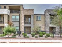 Modern multi-level townhome with stone and siding, showcasing a manicured front yard and wrought iron fence at 1120 Tektite Ave, Henderson, NV 89011