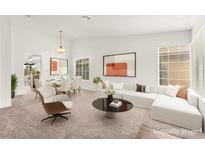 Bright, staged living room featuring modern furniture, large windows, and an open dining area at 1405 Wintergreen Dr, Las Vegas, NV 89128
