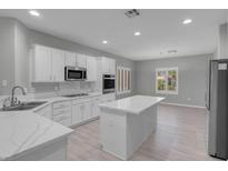 Bright, open kitchen features white cabinets, stone countertops, and stainless steel appliances at 2144 Mountain City St, Henderson, NV 89052