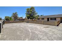 Spacious front yard with a concrete fence that surrounds the property and a home in the background at 2315 Lincoln Rd, Las Vegas, NV 89115