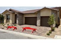 Charming single-story home with a two-car garage, beautiful stone accents, and decorative front yard benches at 344 Tigullio Ave, Henderson, NV 89011