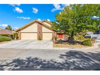 Charming single-Gathering home featuring a 2-car garage, a red door and a nicely landscaped front yard at 3930 Maranatha Cir, Las Vegas, NV 89103