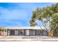 Charming single-story home with a freshly painted exterior, large tree, and well-manicured landscaping at 408 Bolsa Dr, Las Vegas, NV 89110