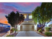Charming home featuring a two-car garage, desert landscaping, and a picturesque sunset backdrop at 6187 Novelty St, Las Vegas, NV 89148