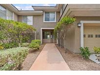 Charming townhome featuring a welcoming walkway, mature landscaping, and a one-car garage at 664 Peachy Canyon Cir # 103, Las Vegas, NV 89144
