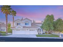 Stunning two-story home with a three-car garage and lush landscaping at 8100 Lake Hills Dr, Las Vegas, NV 89128
