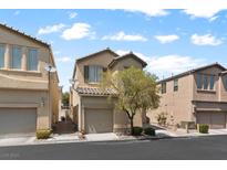 A quaint two-story home with a tan exterior, featuring a single-car garage and mature landscaping at 8448 Quarentina Ave, Las Vegas, NV 89149