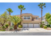 Elegant two-story home with a tile roof, three-car garage, balcony, and mature palm tree landscaping at 8825 Rozetta Ct, Las Vegas, NV 89134
