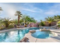 Beautiful pool area featuring a rock waterfall, spa, and lush landscaping at 1239 N Hollywood Blvd, Las Vegas, NV 89110