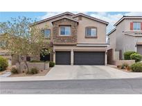 Charming two-story home with a two-car garage and stone accents, set against a bright blue sky at 176 Dunblane St, Henderson, NV 89012
