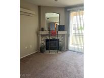 Spacious living room with a decorative fireplace and natural light streaming through the sliding glass door at 1830 N Buffalo Dr # 2021, Las Vegas, NV 89128