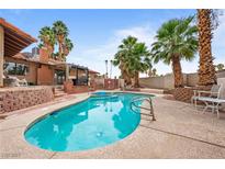 Sparkling pool with mature palms, and ample deck and lounge areas creates a resort-like backyard oasis at 3135 La Mesa Dr, Henderson, NV 89014