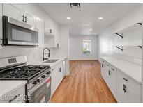 Modern kitchen featuring white cabinets, stainless steel appliances, and a gas range at 3907 Torsby Pl, Las Vegas, NV 89119