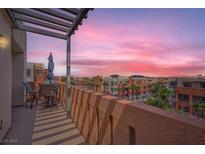 Balcony view overlooking community buildings and sunset, with seating under a pergola at 63 E Agate Ave # 509, Las Vegas, NV 89123