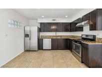 A kitchen featuring stainless steel appliances and granite countertops with tile flooring at 882 Westminster Ave, Las Vegas, NV 89119