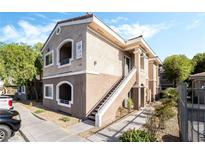 Two-story condo building with neutral paint, white trim, and stair access to upper units at 9330 W Maule Ave # 138, Las Vegas, NV 89148
