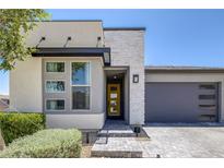 Contemporary home featuring stone accents, a yellow front door and a two-car garage at 9617 Sard Ln, Las Vegas, NV 89143