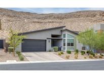 Modern home with a flat roof, two-car garage, desert landscaping, and mountain views at 9789 Twilight Moon Ave, Las Vegas, NV 89148