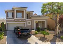 Charming two-story home with a well-manicured front yard, desert landscaping, and an attached two-car garage at 10316 Neopolitan Pl, Las Vegas, NV 89144