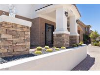 Charming home entrance with stone accents, desert landscaping, and a covered porch for a grand arrival at 1319 Red Baron Ln, Boulder City, NV 89005