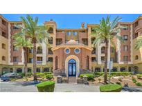 Beautiful condo exterior with manicured landscaping and swaying palm trees on a bright sunny day at 15 Via Mantova # 302, Henderson, NV 89011