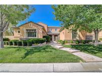 Charming two-story home with beautifully landscaped front yard and walkway leading to gated entrance at 16 Mallard Creek Trl, Henderson, NV 89052