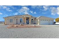 Attractive single story home featuring a three car garage and desert landscaping at 3580 Prairie Ave, Pahrump, NV 89048