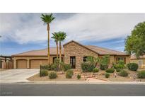 Charming single-story home featuring a stone facade, three-car garage, and well-manicured landscaping at 8032 Audubon Canyon St, Las Vegas, NV 89131
