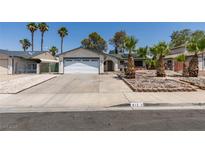 Single-story home with a two-car garage, mature landscaping, and a well-maintained front yard at 813 Cherry Dr, Henderson, NV 89002