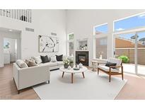 Bright living room with fireplace, modern decor, and large windows providing natural light at 9011 Aldershot Ct, Las Vegas, NV 89147