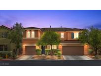 Charming two-story home with well-manicured landscaping and a welcoming front entrance at dusk at 10300 S Dapple Gray Rd, Las Vegas, NV 89178