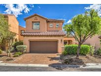 Charming two-story home features a tile roof, desert landscaping, and an attached two-car garage at 1064 Calvia St, Las Vegas, NV 89138