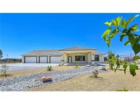 Charming single-story home featuring a spacious three-car garage and desert landscaping for low maintenance at 1351 Huckleberry St, Pahrump, NV 89048