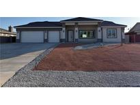 Contemporary single-story home featuring a two-car garage and desert landscaping at 2150 S Manzanita Dr, Pahrump, NV 89048