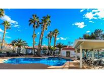Community pool featuring lounge chairs, palm trees, and a covered seating area, perfect for relaxation at 2725 S Nellis Blvd # 2005, Las Vegas, NV 89121