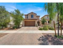 Charming two-story home showcasing a desert landscaped front yard and two-car garage, with a tile roof at 348 Andy Wheeler Dr, Henderson, NV 89011