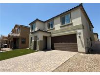 Two story home showcasing a two car garage, paved driveway and low maintenance artificial grass at 4104 Free Bird Crest Ave, North Las Vegas, NV 89081