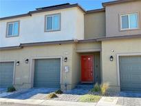 Beautful townhouse featuring an attached garage, stone details and a bright red front door at 4273 Venus Falls Ave, North Las Vegas, NV 89084