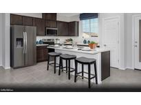 Modern kitchen features a large island with seating, stainless steel appliances, and dark wood cabinetry at 5765 Crenellated St # Lot 59, Las Vegas, NV 89148